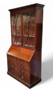 A Victorian mahogany and satinwood inlaid secretaire bookcase, the oversailing dental cornice