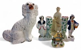 A Staffordshire spaniel, seated to the left, 30cm high,  c.1880;   a pair of Staffordshire figural
