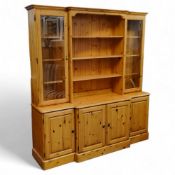 A Ducal Furniture waxed pine breakfront dresser, three shelves to centre flanked by glazed cupboards