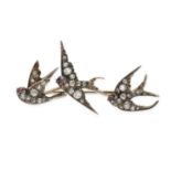 A FINE ANTIQUE DIAMOND SWALLOW BROOCH in silver and yellow gold, designed as three flying swallow...