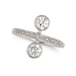 A DIAMOND DRESS RING in platinum, set with two transitional cut diamonds, the band accented by ro...