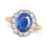AN UNHEATED SAPPHIRE AND DIAMOND CLUSTER RING in yellow gold, set with an oval cut sapphire of 3....