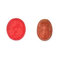 A MOULDED GLASS INTAGLIO AND A CARVED SCARAB BEETLE the red glass intaglio moulded to depict Cupi...