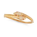 A RUBY AND DIAMOND SNAKE BANGLE in yellow gold, designed as two coiled snakes, the eyes set with ...
