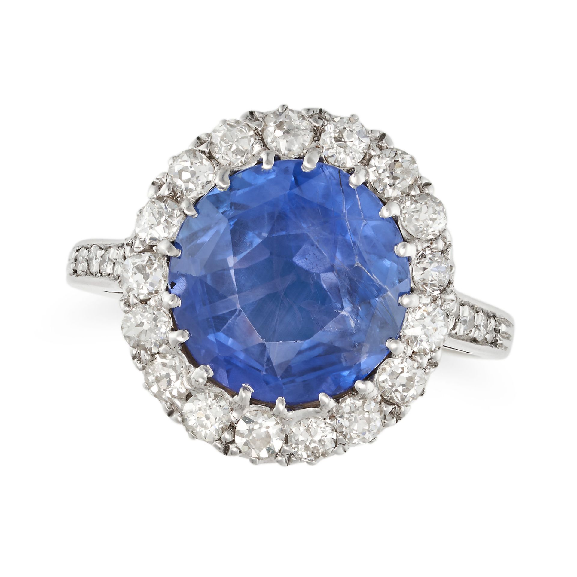 A SAPPHIRE AND DIAMOND CLUSTER RING in white gold, set with a round cut sapphire of approximately...