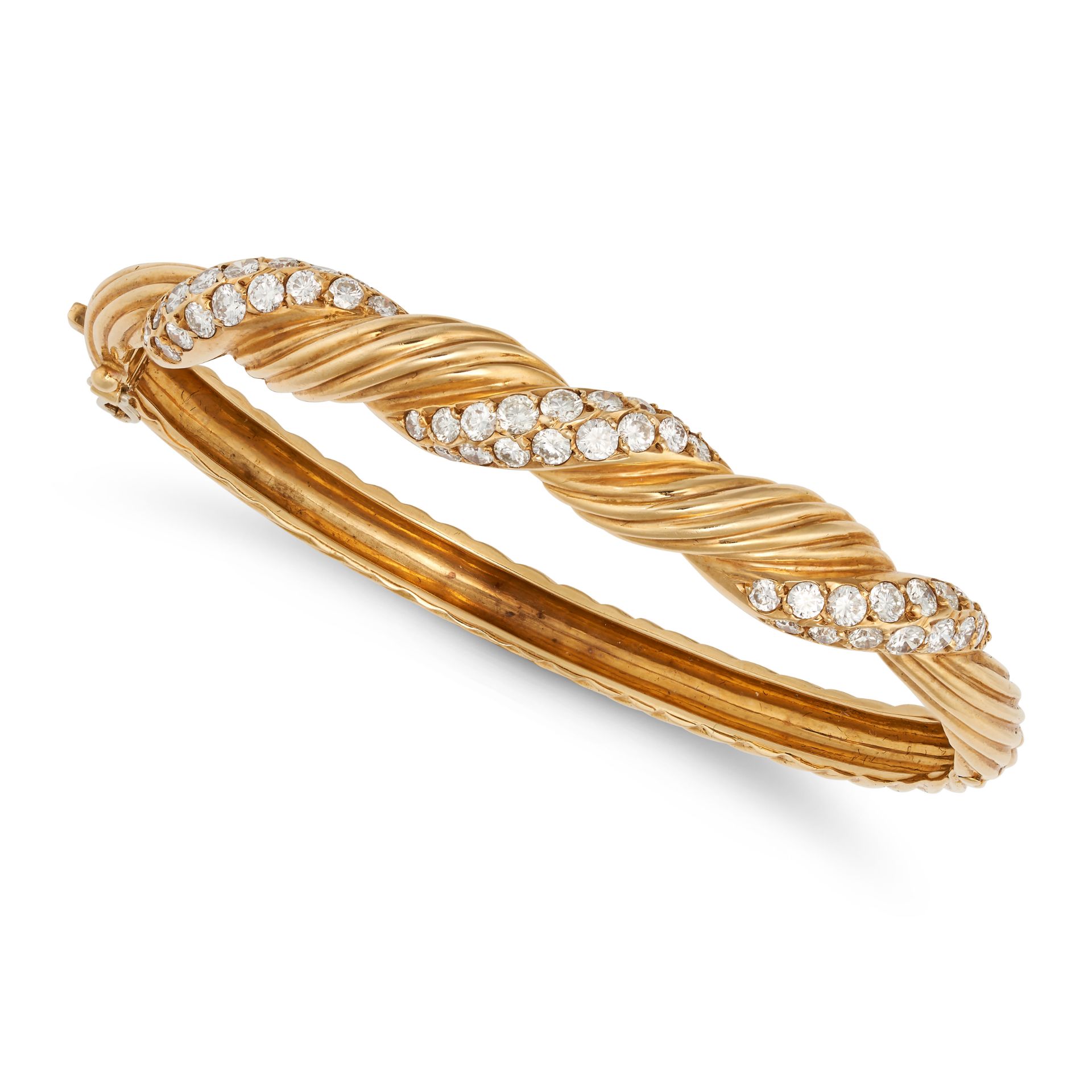VAN CLEEF & ARPELS, A DIAMOND BANGLE in 18ct yellow gold, the twisted hinged bangle accented by s...