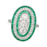 AN EMERALD AND DIAMOND DRESS RING in platinum, the oval face set with a cluster of old cut diamon...