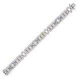 A DIAMOND AND SAPPHIRE BRACELET in platinum and white gold, the openwork bracelet set throughout ...