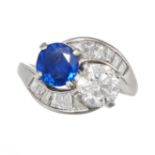 A SAPPHIRE AND DIAMOND TOI ET MOI RING in platinum, set with a round cut sapphire of approximatel...