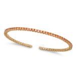 AN ORANGE SAPPHIRE BRACELET in 18ct yellow gold, the open bangle set with a row of round cut oran...