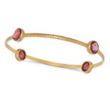 A PINK TOURMALINE BANGLE in 18ct yellow gold, the hammered gold bangle set with four fancy cut pi...