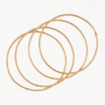 A SET OF FOUR GOLD BANGLES in 18ct yellow gold, each bangle having a singular gold bead intersect...