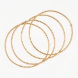 A SET OF FOUR GOLD BANGLES in 18ct yellow gold, each bangle having a singular gold bead intersect...
