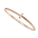 A BANGLE in 14ct rose gold, half the band set with diamonds, stamped Au585, 10.5g.