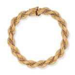 A VINTAGE GOLD BRACELET in 18ct yellow and white gold, comprising a row of twisted links accented...