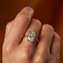 A 5.76 CARAT DIAMOND SOLITAIRE RING set with an oval cut diamond of 5.76 carats, stamped 750, siz...