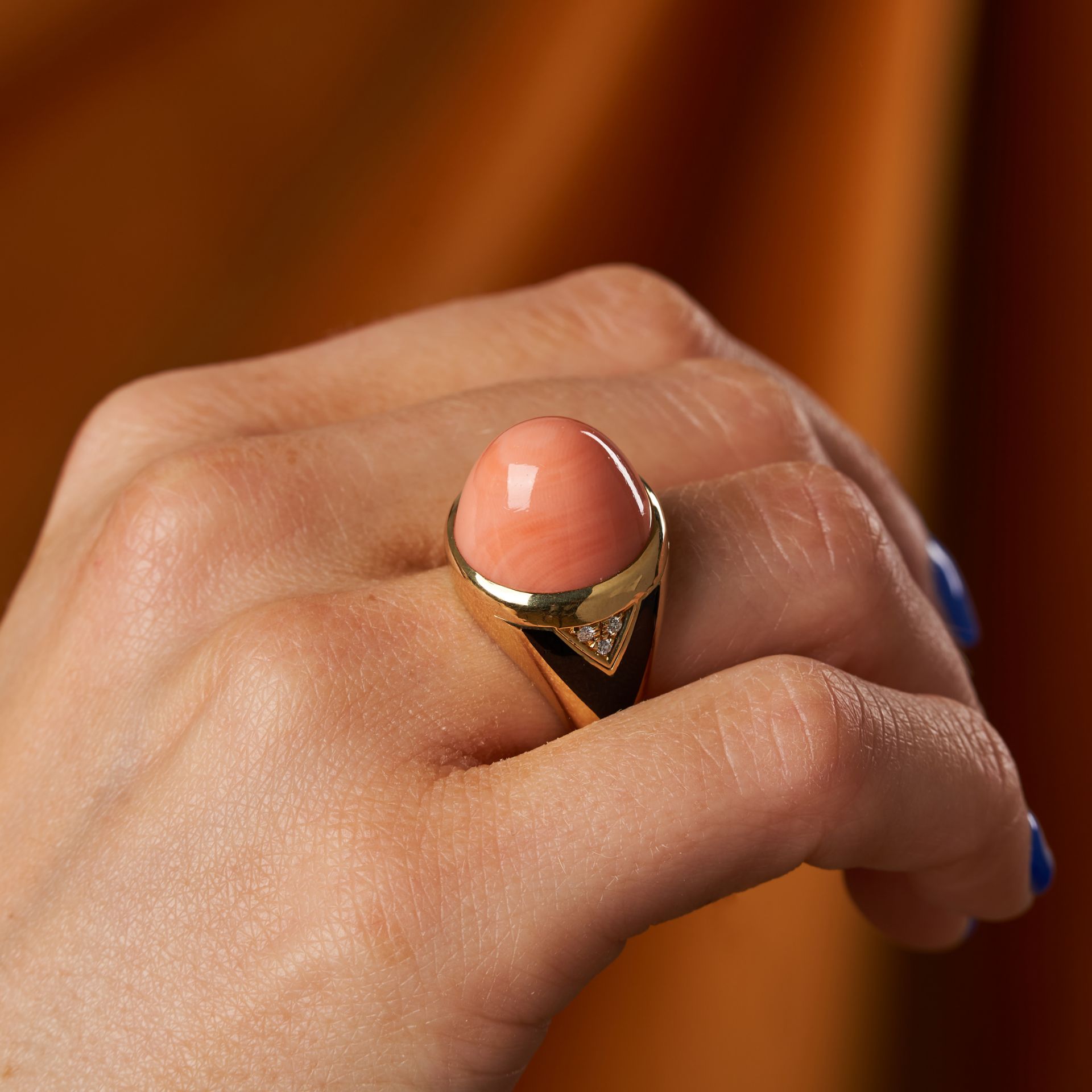 BULGARI, A VINTAGE CORAL, DIAMOND AND ONYX RING in 18ct yellow gold, set with a cabochon coral, t...