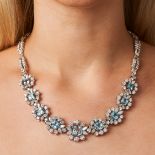 AN AQUAMARINE AND DIAMOND CLUSTER NECKLACE set with nine cushion cut aquamarines in clusters of r...