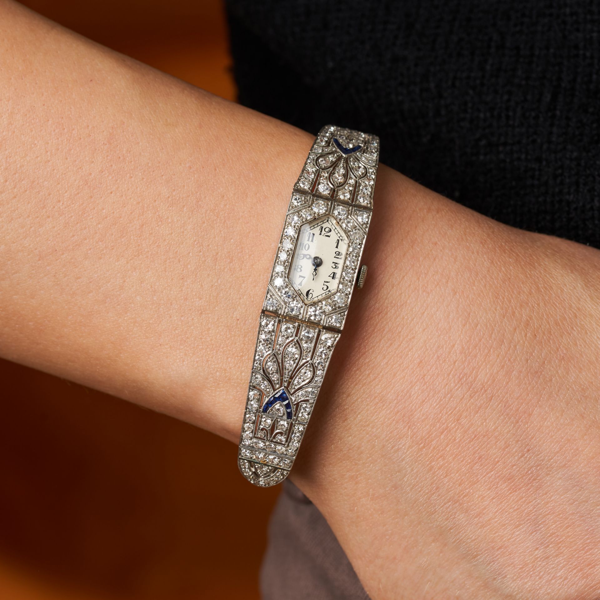 AN ART DECO SAPPHIRE AND DIAMOND COCKTAIL WATCH in platinum, the hexagonal watch face accented by...