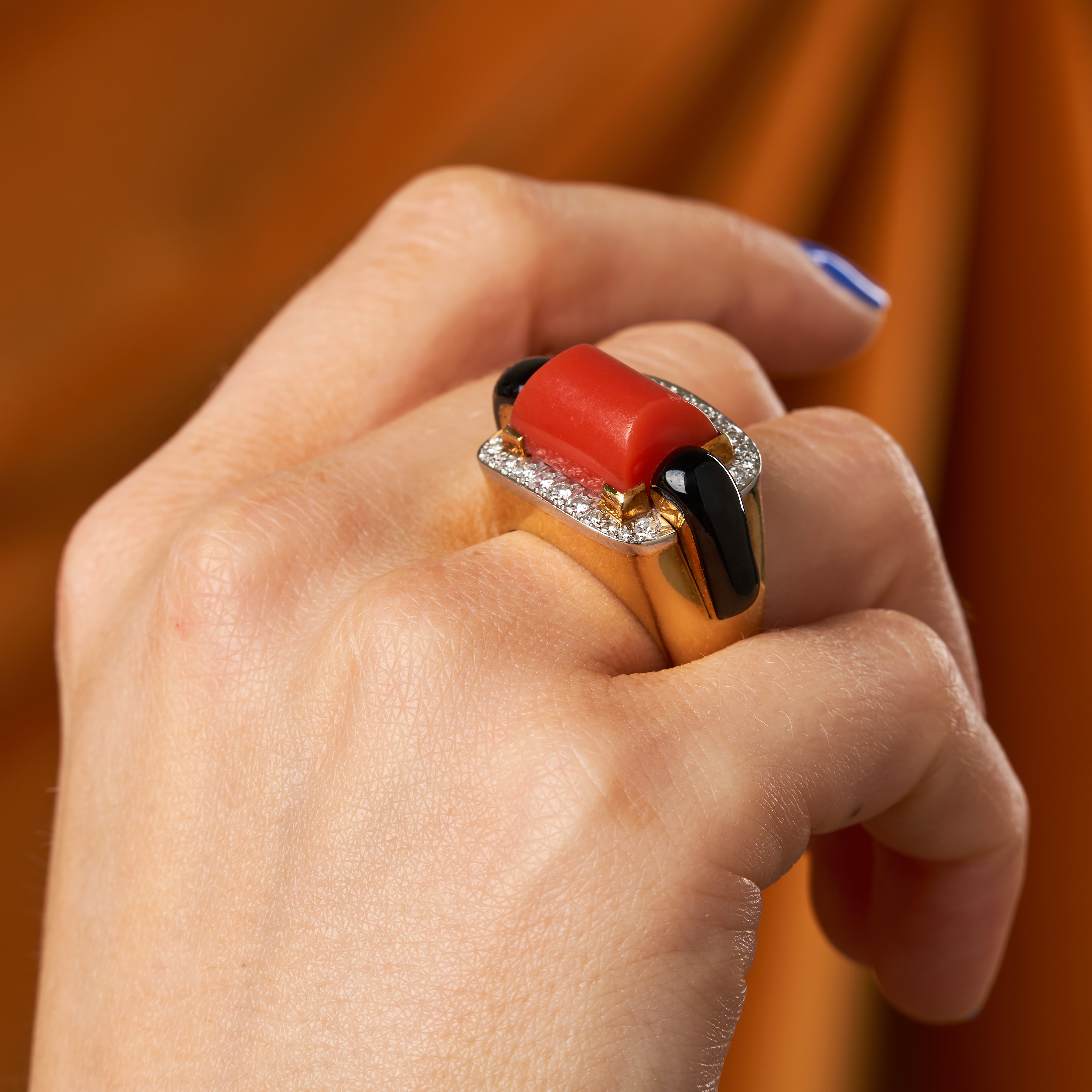DAVID WEBB, A CORAL, DIAMOND AND ONYX RING set with a polished coral accented by polished onyx an...