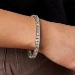 A FINE DIAMOND LINE BRACELET comprising a row of rectangular step cut diamonds, the diamonds all ...