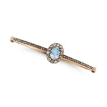 AN ANTIQUE AQUAMARINE AND DIAMOND BANGLE in yellow gold, the hinged bangle set with an oval cut a...