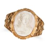 AN ANTIQUE CONCH SHELL CAMEO BANGLE in yellow gold, set with an oval conch shell cameo carved to ...