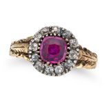 AN ANTIQUE RUBY AND DIAMOND RING in yellow gold and silver, set with a cushion cut ruby in a bord...