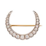 A DIAMOND CRESCENT MOON BROOCH in yellow gold, designed as a crescent moon set with a row of roun...