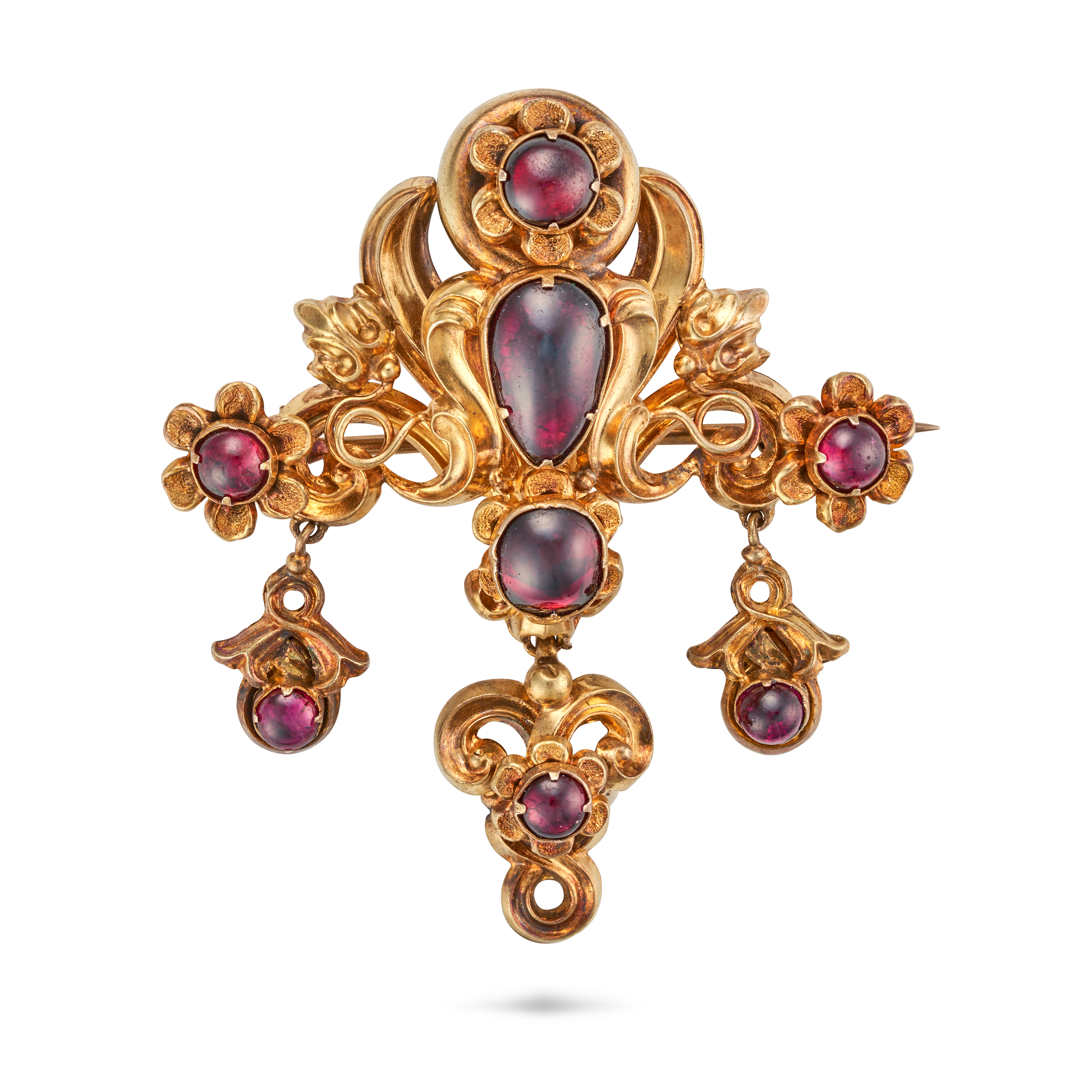 AN ANTIQUE GARNET BROOCH in yellow gold, the scrolling body set with oval and pear shaped cabocho...