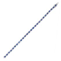 A SAPPHIRE AND DIAMOND LINE BRACELET comprising a row of oval cut sapphires accented by pairs of ...
