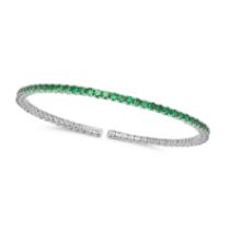 A TSAVORITE GARNET BANGLE in 18ct white gold, the open bracelet set with a row of round cut tsavo...
