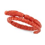 AN ANTIQUE CORAL DRAGON BANGLE the head carved from a single piece of coral, the body formed of s...