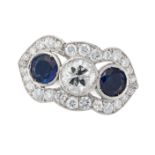 A DIAMOND AND SAPPHIRE DRESS RING set with a round cut diamond of approximately 0.52 carats betwe...