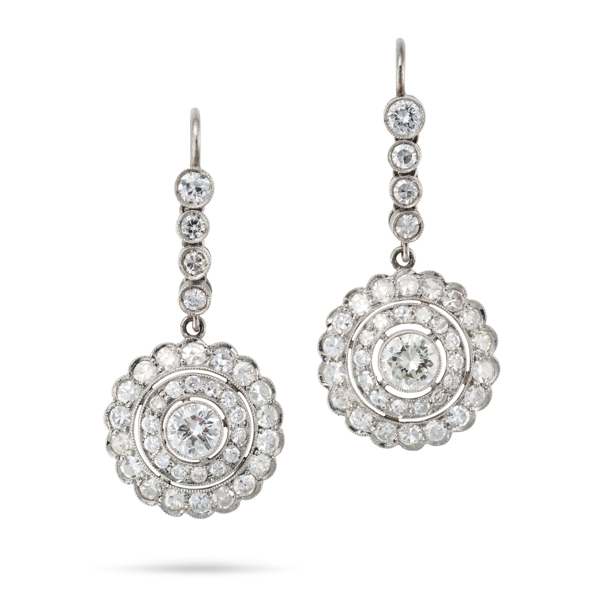 A PAIR OF DIAMOND CLUSTER DROP EARRINGS each comprising a row of round cut diamonds, suspending a...