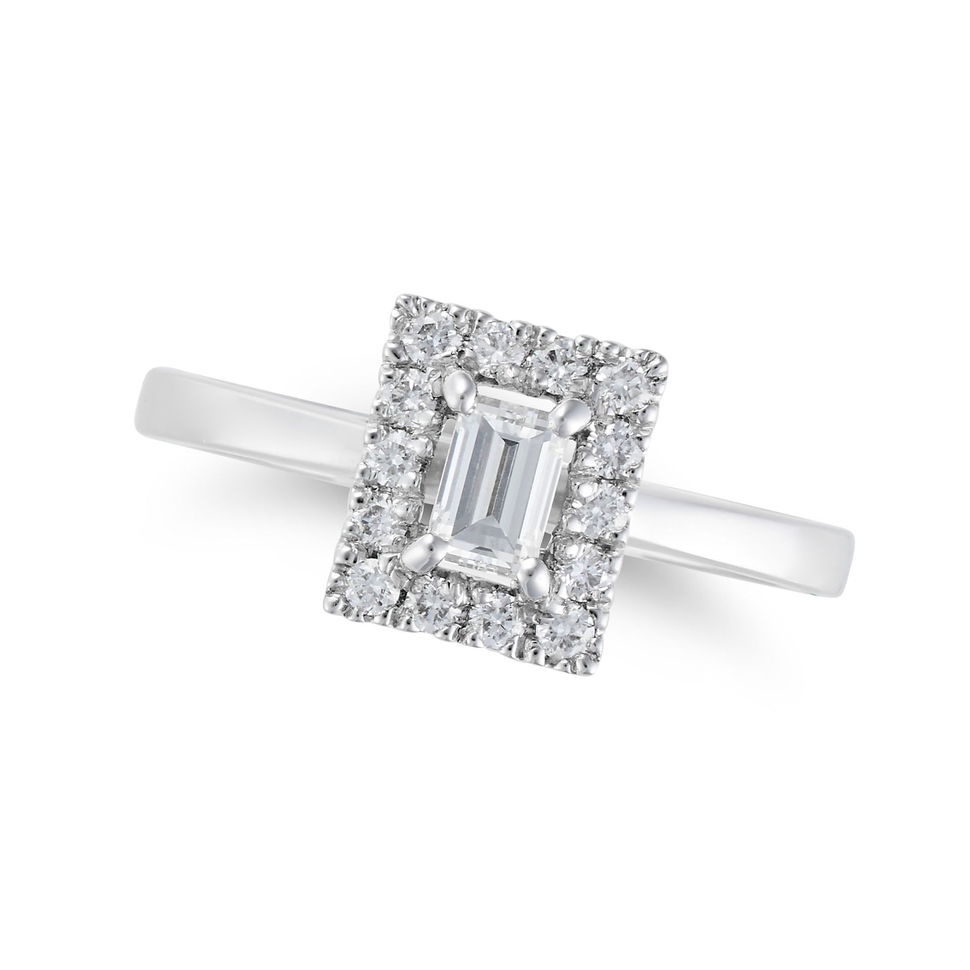 A DIAMOND RING in platinum, set with a baguette cut diamond in a border of round brilliant cut di...