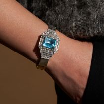 AN AQUAMARINE AND DIAMOND BANGLE the hinged bangle set with an octagonal step cut aquamarine of a...