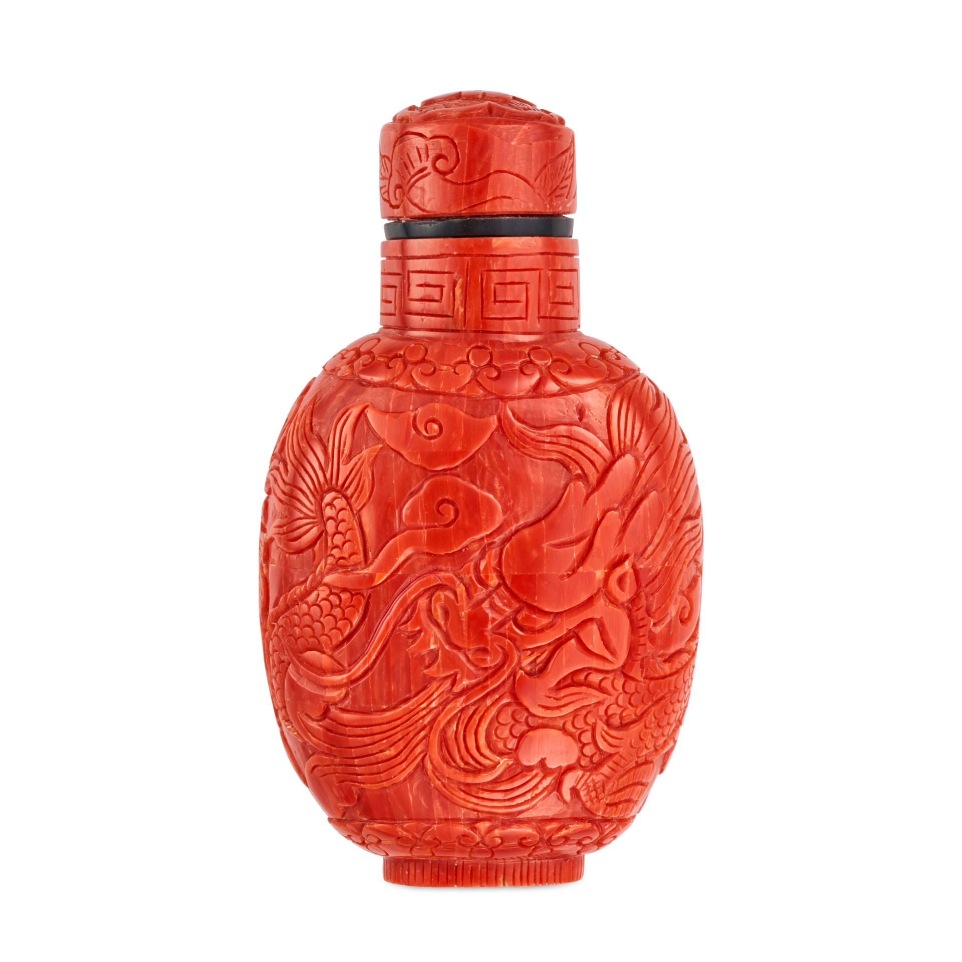 AN ANTIQUE CHINESE CORAL SNUFF BOTTLE comprising coral carved to depict dragons, the lid lifting ...