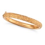 AN ANTIQUE GOLD BANGLE in 18ct yellow gold, the hinged bangle engraved with foliate design, stamp...