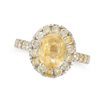 A YELLOW SAPPHIRE AND DIAMOND CLUSTER RING set with an oval cut yellow sapphire of approximately ...