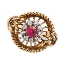 A VINTAGE RUBY AND DIAMOND RING in yellow gold, set with a round cut ruby in a cluster of old cut...