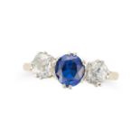 A SAPPHIRE AND DIAMOND THREE STONE RING set with an oval cut sapphire between two old cut diamond...
