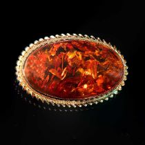 A 9 CARAT YELLOW GOLD AND AMBER OVAL BROOCH
