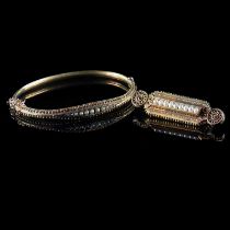 A LATE VICTORIAN 15 CARAT YELLOW GOLD AND SEED PEARL HINGED BANGLE