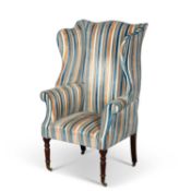AN EARLY 19TH CENTURY MAHOGANY AND UPHOLSTERED WING-BACK ARMCHAIR