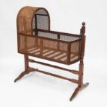 A REGENCY MAHOGANY AND CANEWORK CRADLE