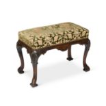 A 19TH CENTURY CARVED WALNUT AND UPHOLSTERED STOOL IN GEORGE II STYLE