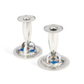 ARCHIBALD KNOX (1864-1933) FOR LIBERTY & CO, A PAIR OF TUDRIC PEWTER AND ENAMEL CANDLESTICKS