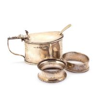 A SILVER MUSTARD POT, BIRMINGHAM 1915, AND TWO SILVER NAPKIN RINGS AND A SPOON