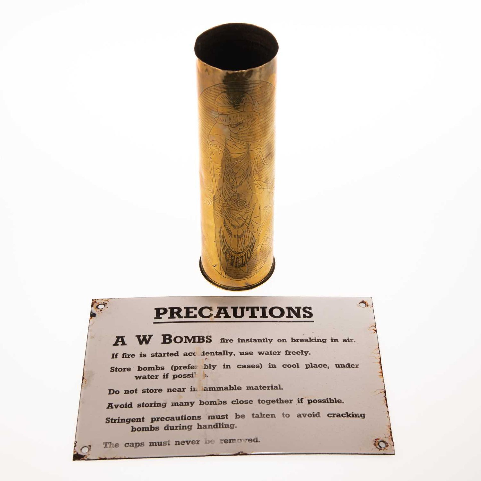 A WWII ENAMEL AMMUNITIONS SIGN AND A BRASS SHELL
